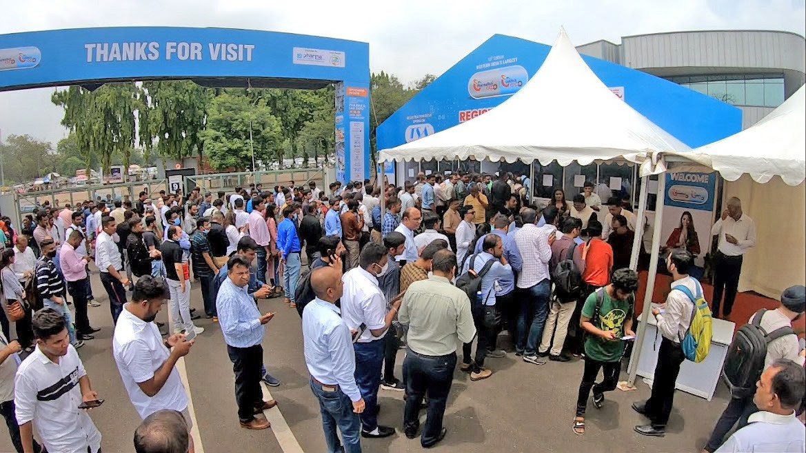 Long queue of pharma professionals registering for Vizag Pharma Lab Chem Expo 2026 at Ramky Pharma City entrance, with attendees waiting to collect visitor passes and badges.