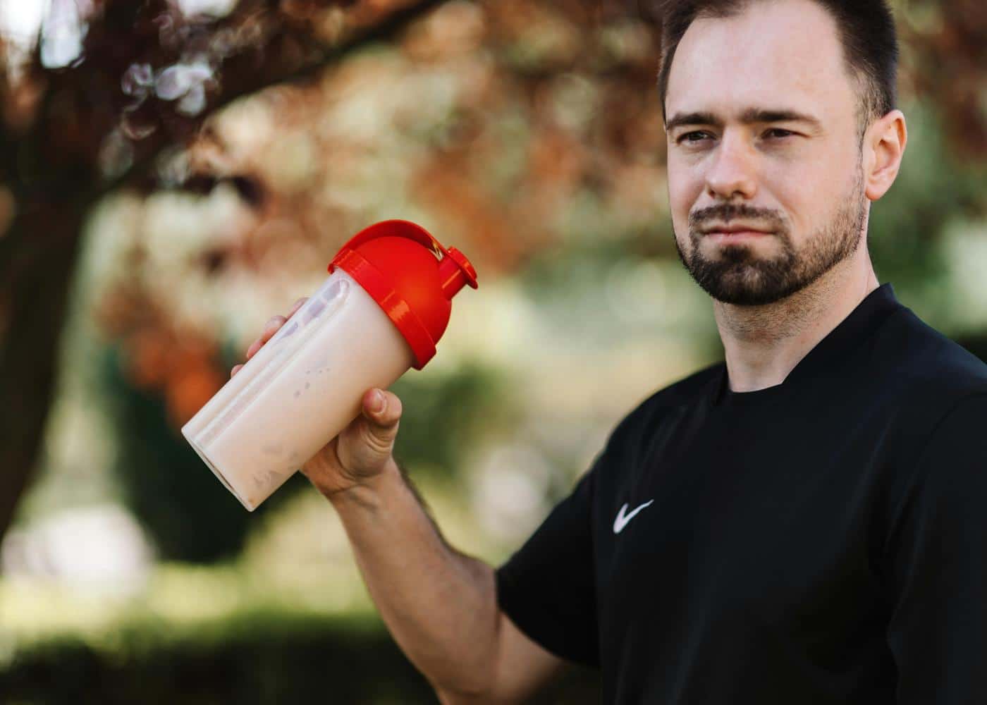 Protein powder and weight gain - man shaking a protein drink