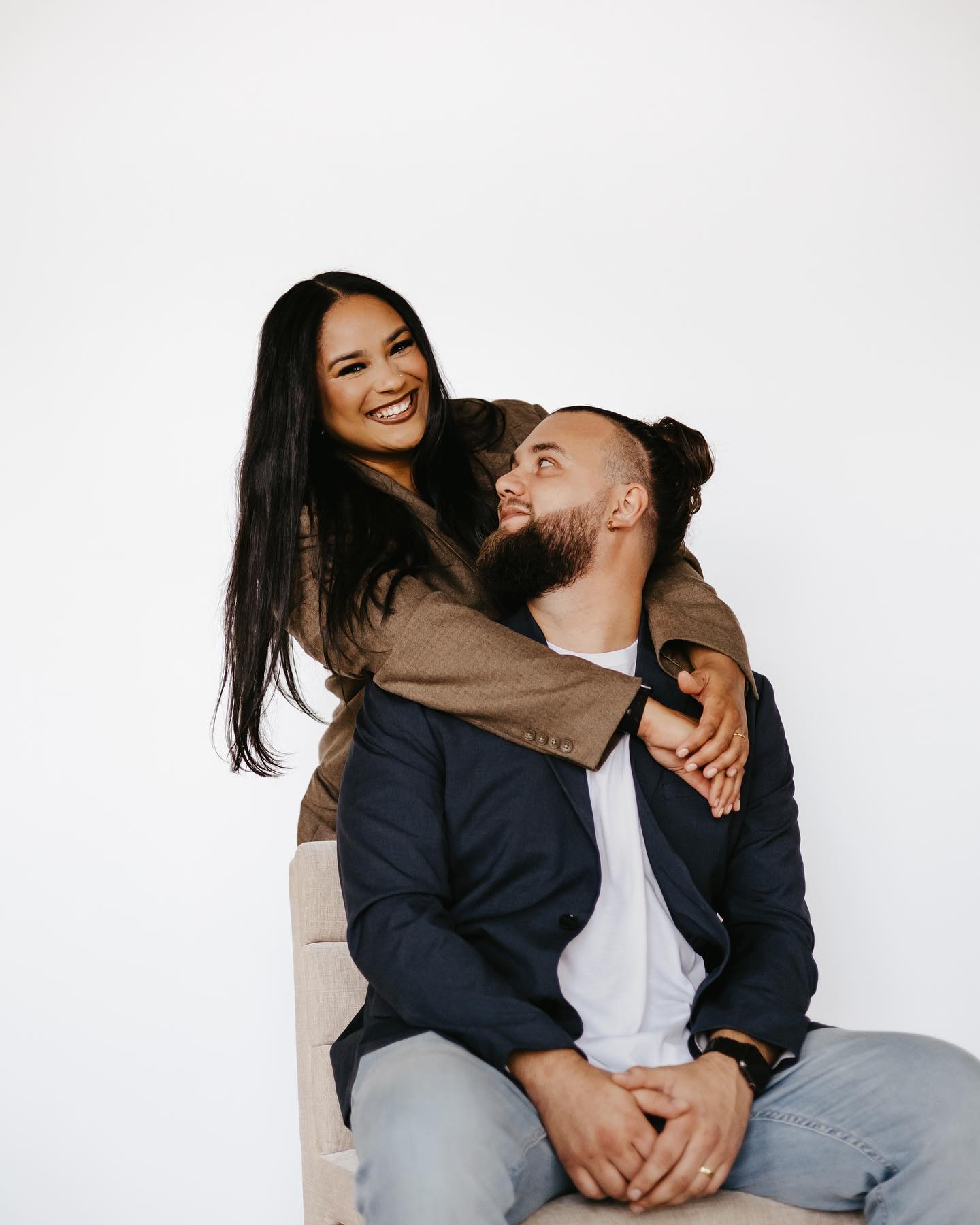 A couple made their bond stronger by hugging affectionately while sitting on a chair.