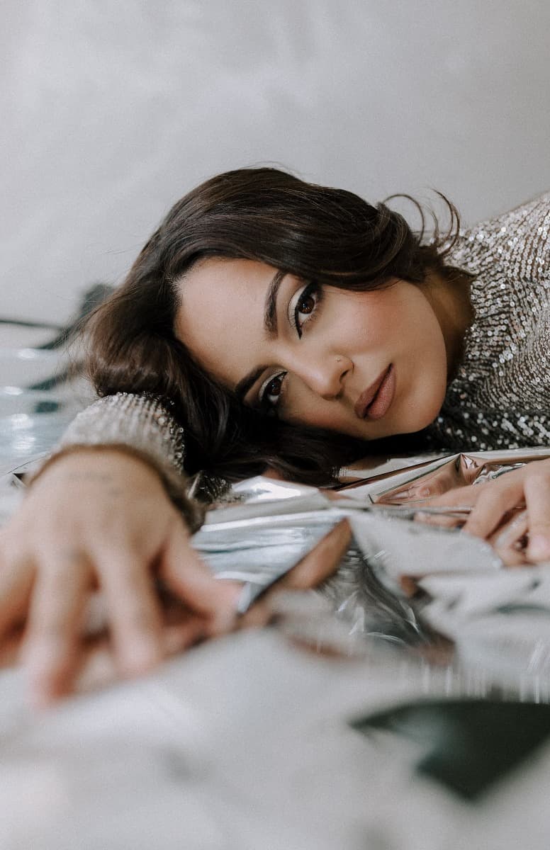 A model stretching out her hand on reflective Mylar, captured during a creative Mylar shoot at Revelator Studio in Shreveport.