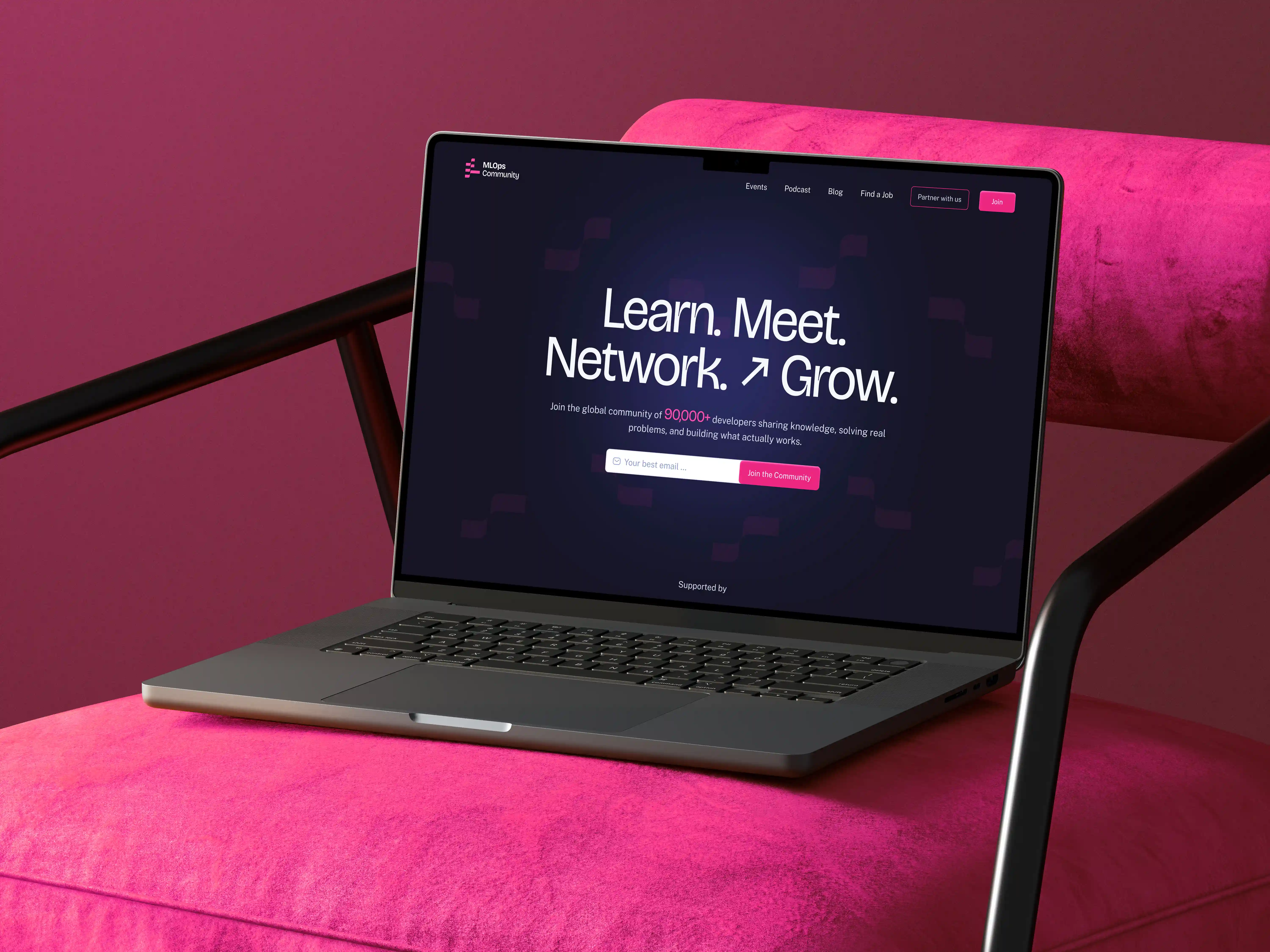 Laptop mockup showcasing the MLOps Community website featuring a dark-themed landing page with bold typography, community-focused messaging, and vibrant pink brand accents.