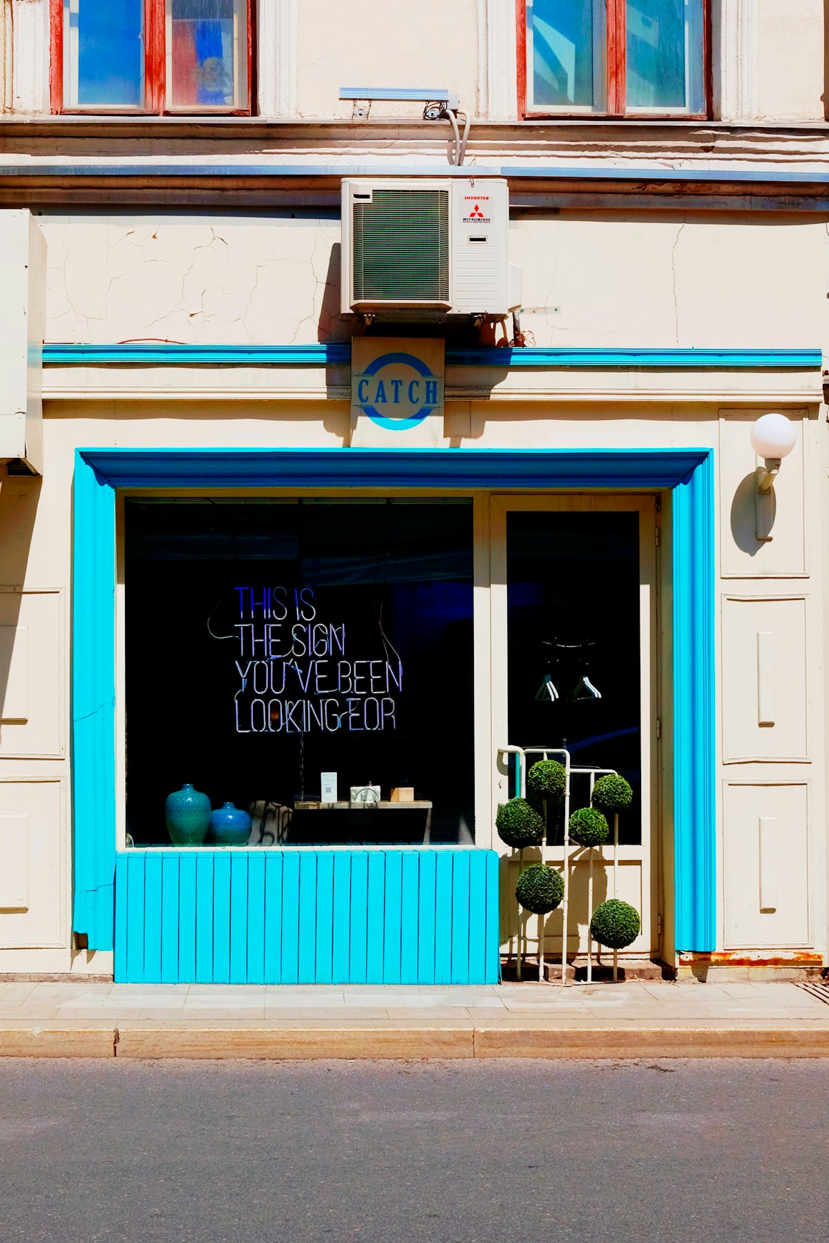Fachada de tienda con ventana azul y letrero