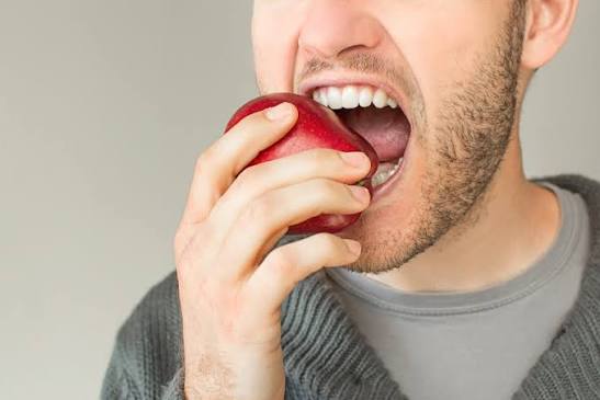 Patient placing a clear dental aligner over her teeth