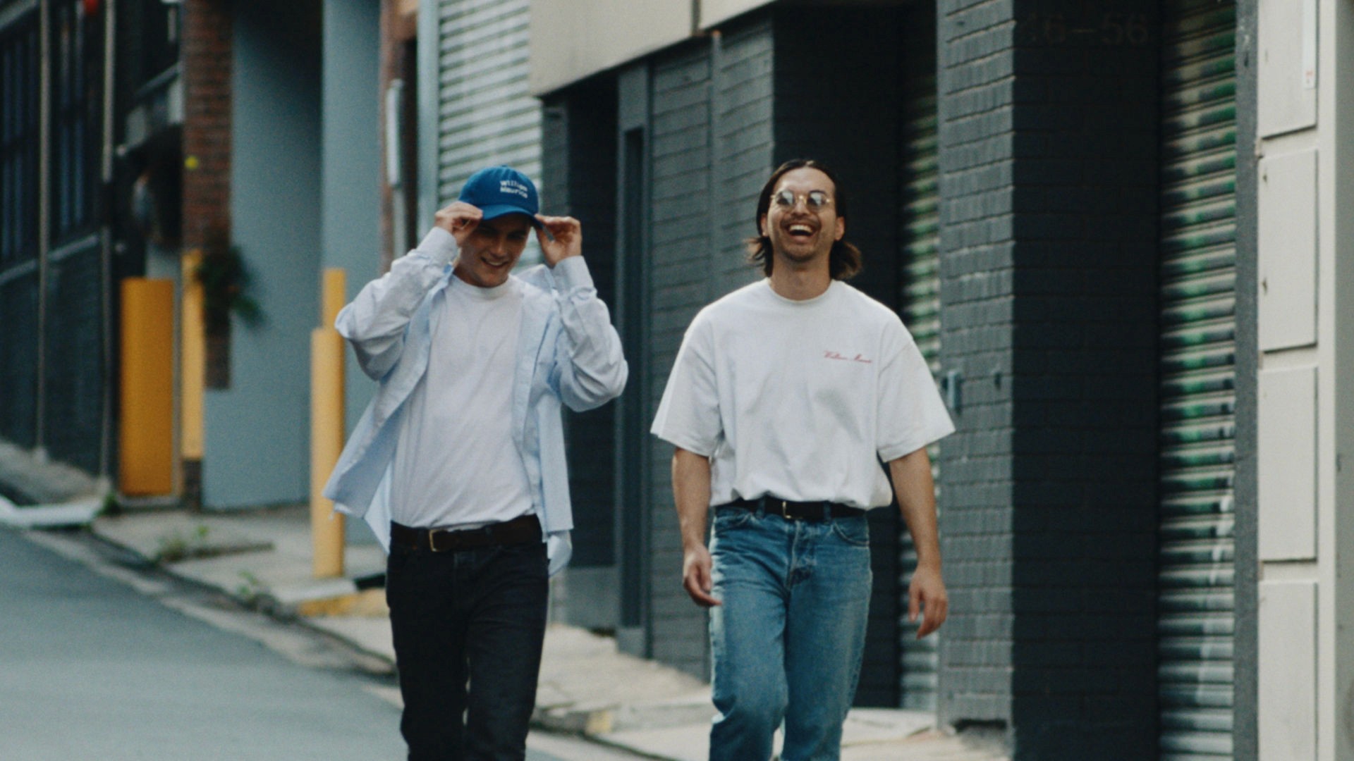 Still from Home for the Weekend campaign of two friends walking down a Sydney alleyway