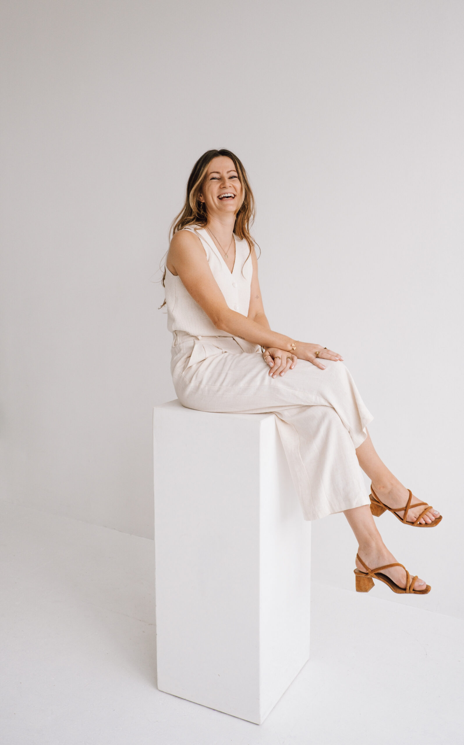 Franzi sitzt lächelnd auf einem weißen Pfahl