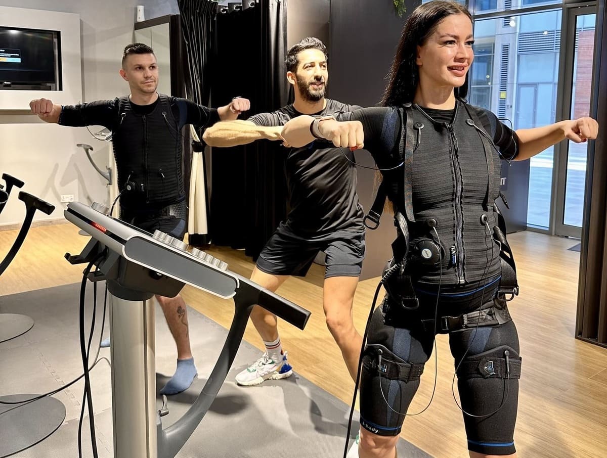 woman in black tank top and black shorts holding barbell