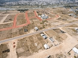 Man running on a winding path through desert badlands.