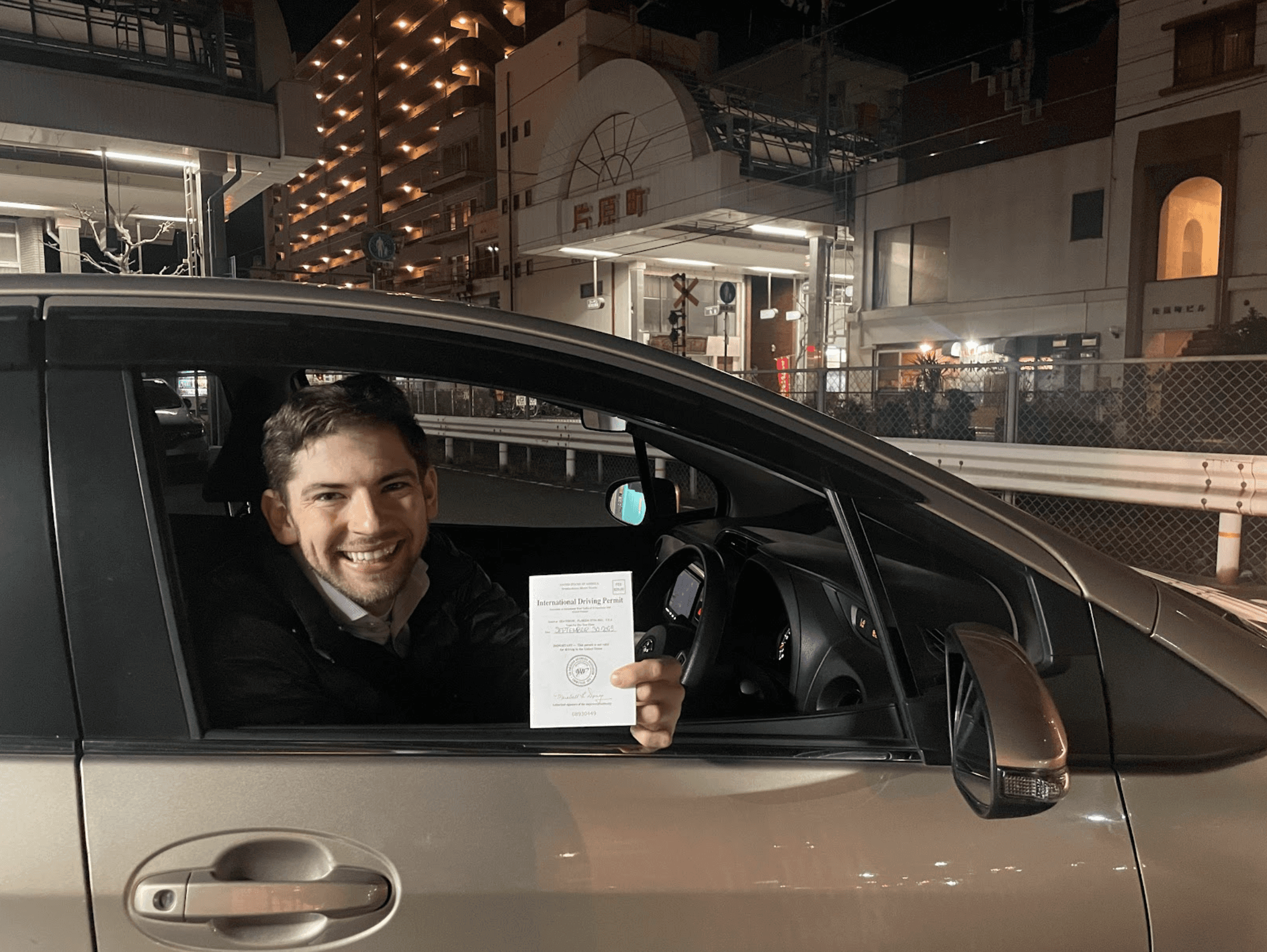 Driver in car in Japan showing an International Driving Permit from AAA
