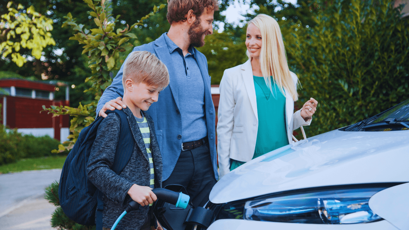 familie foto bij een elktrische auto, jongen met laadkabel in de hand