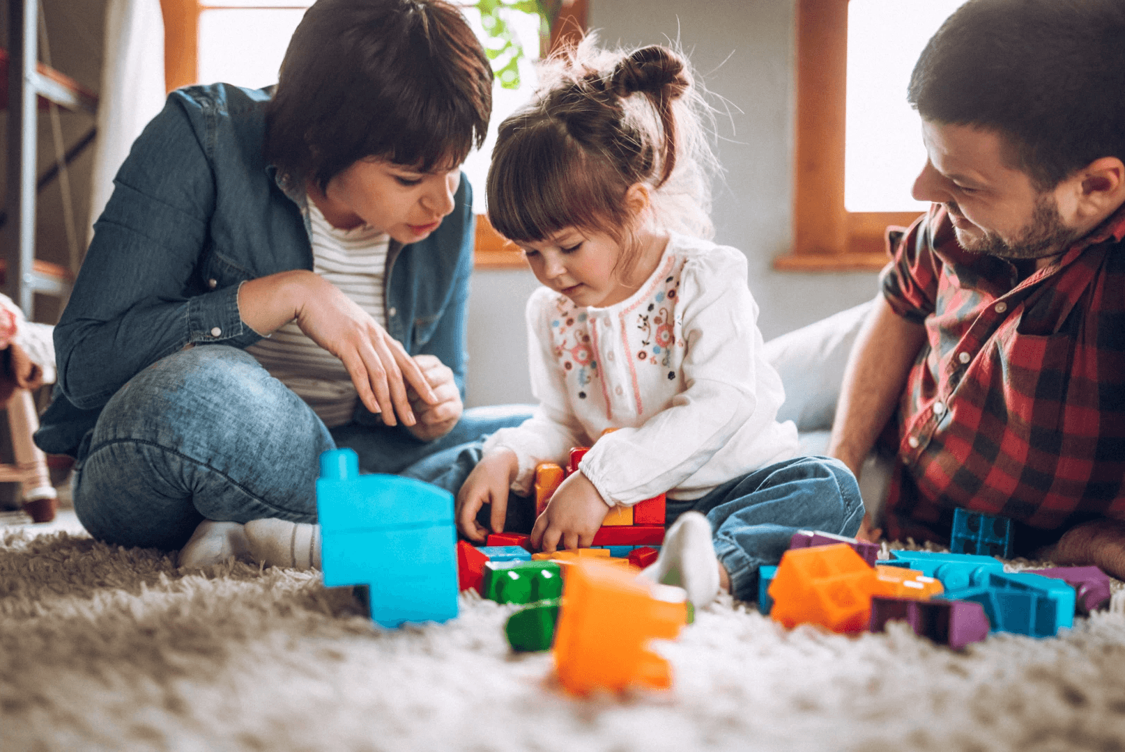 kid playing blocks with parents