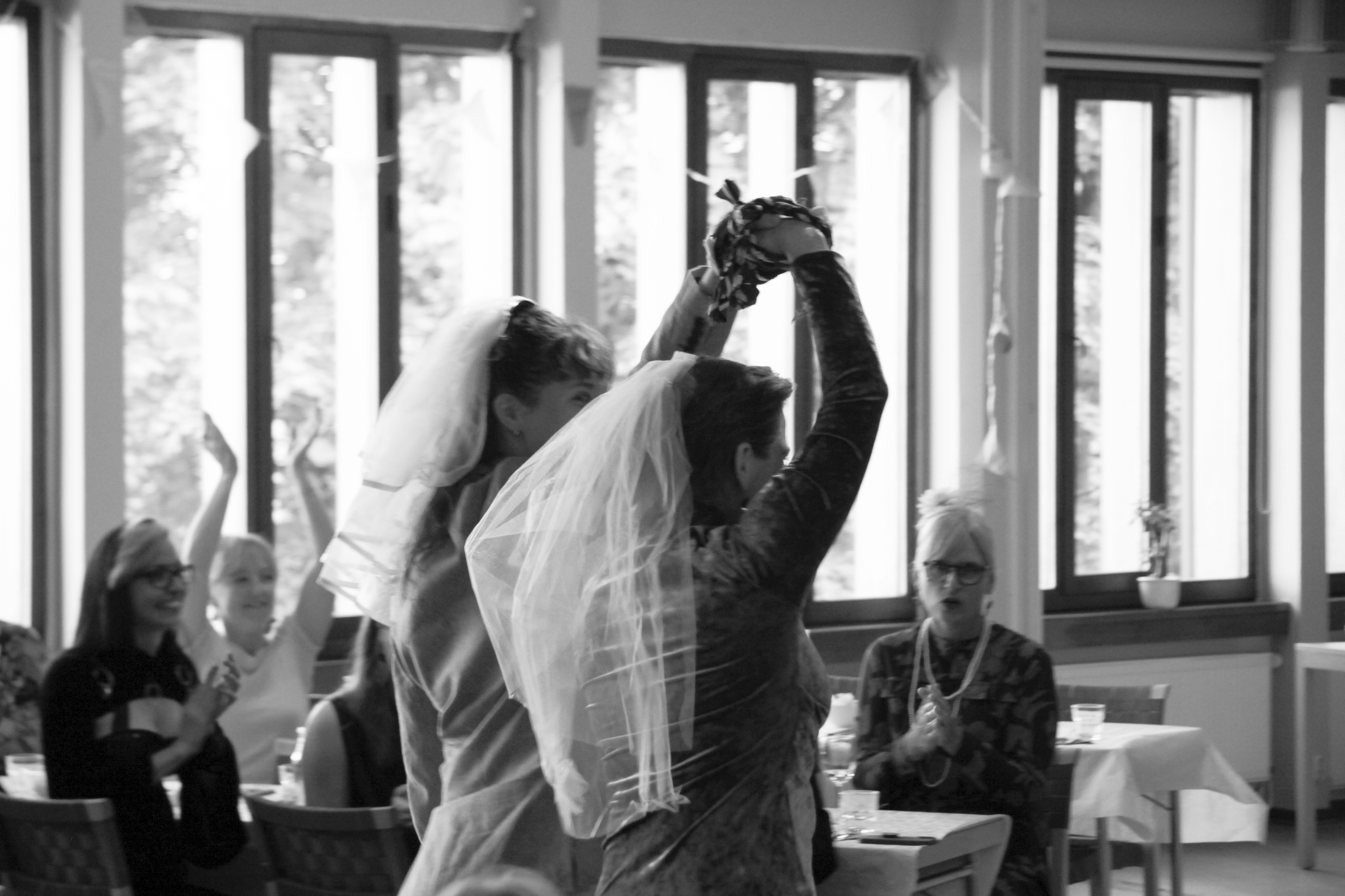 Two people holding hands in wedding attire.