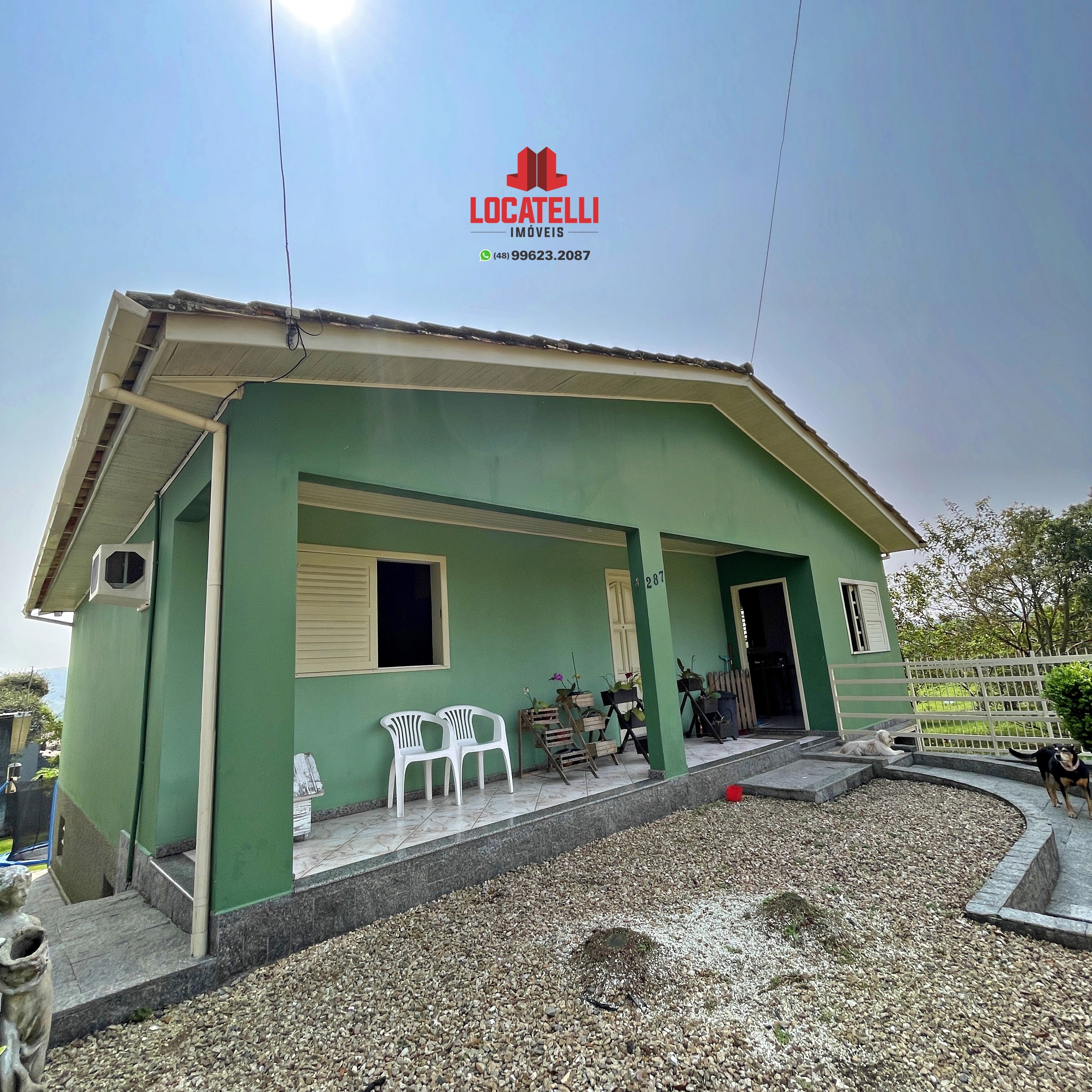 A modern brick house with a two-car garage, well-manicured lawn, and clear blue sky in the background.