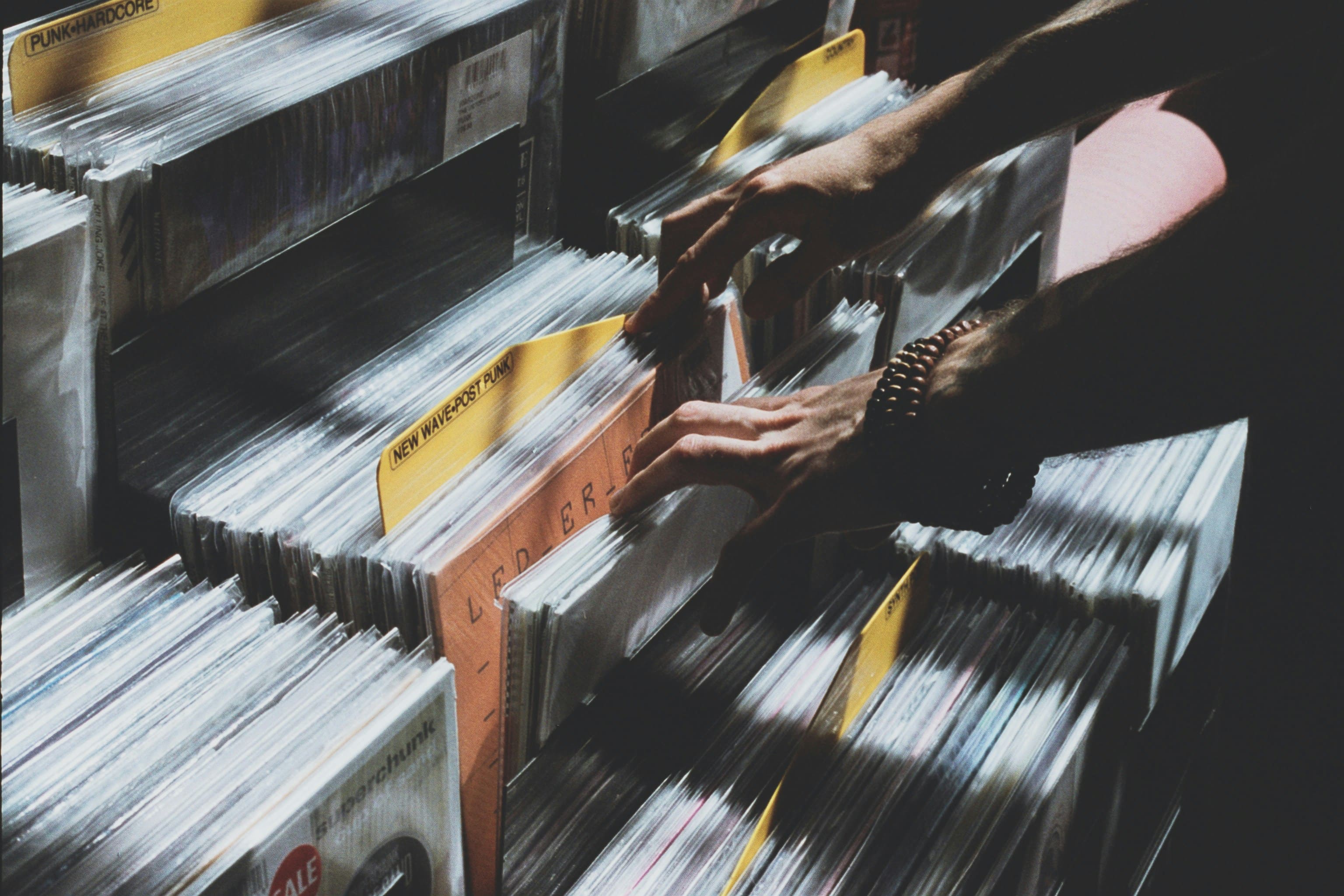 Person browsing vinyl records in a record store crate while digging for music