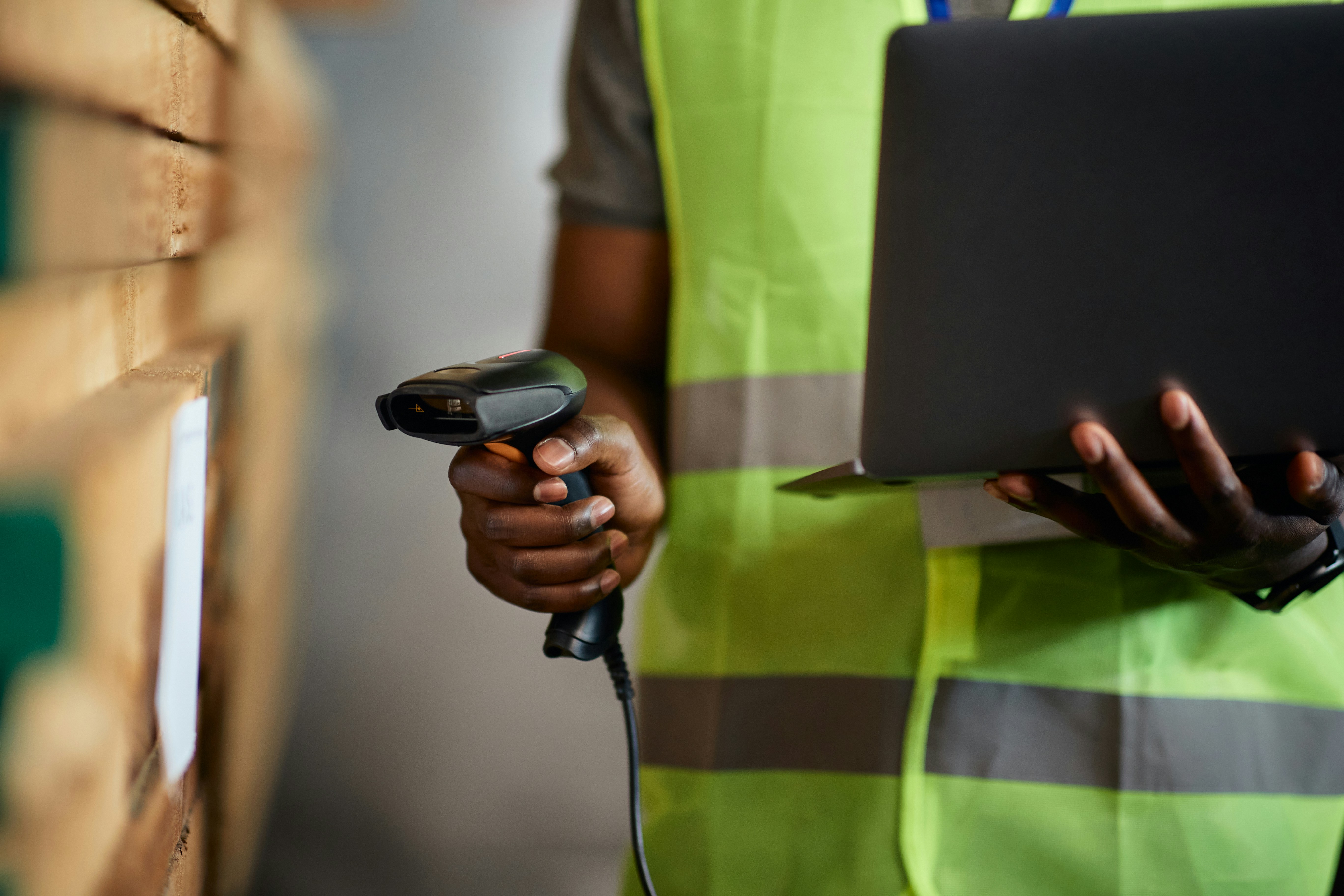 person checks barcode of items with a scanner and laptop