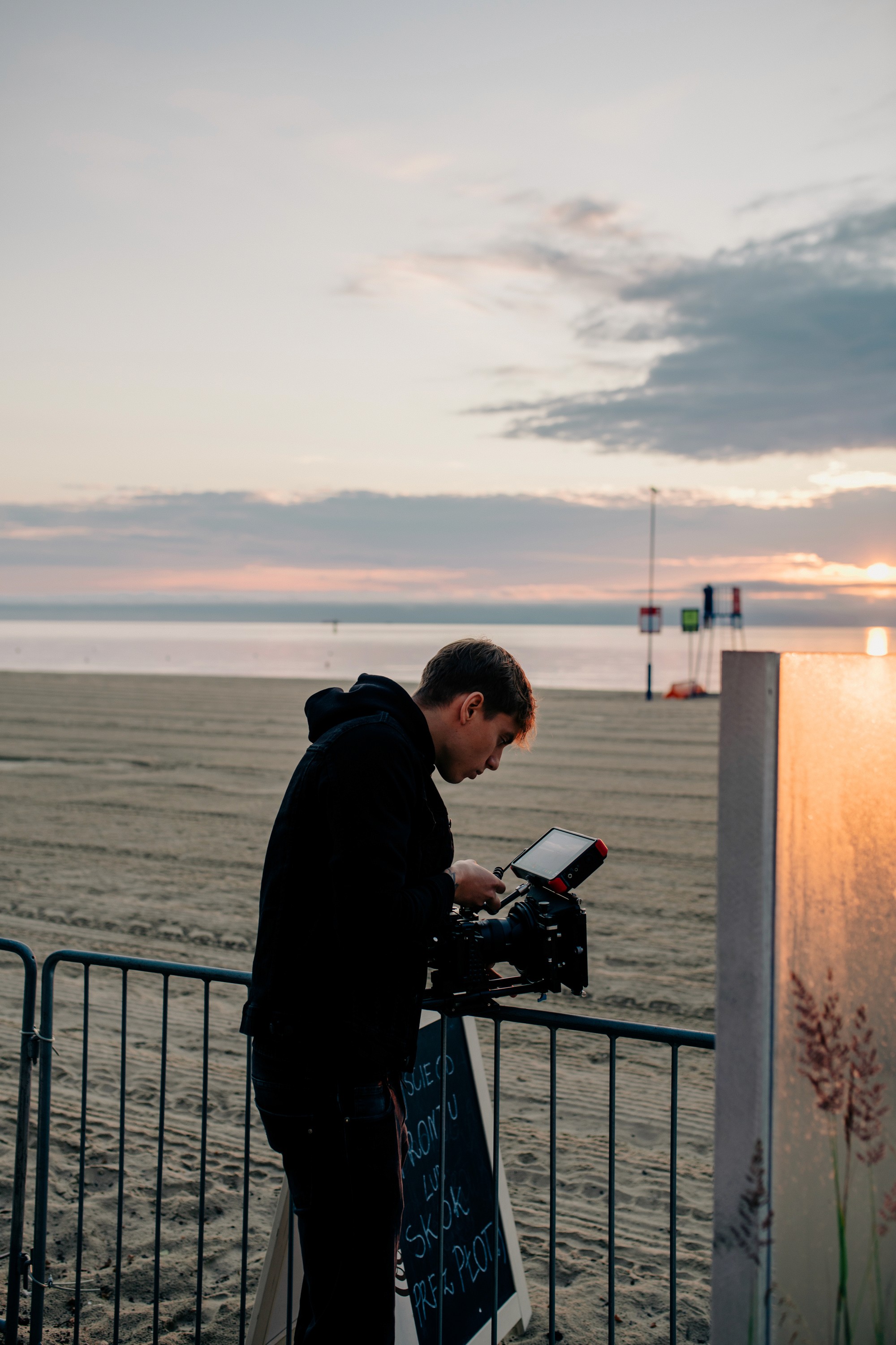 A close-up of a hand wearing multiple decorative rings against a blue background.