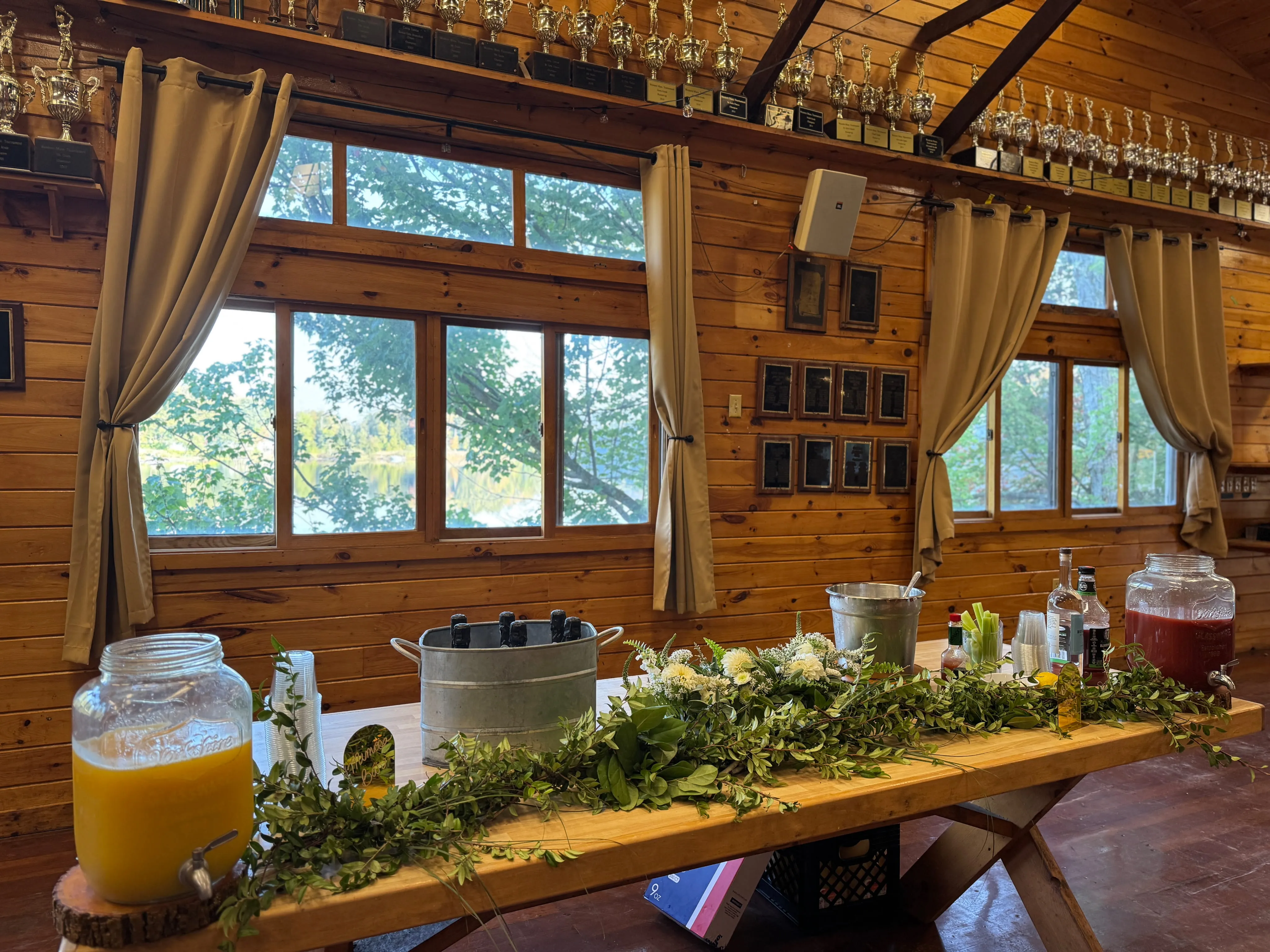 Welcome drink table with greenery in the lodge at Camp Lenox