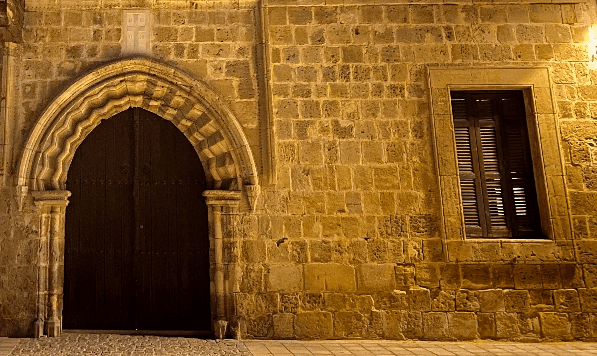 Traditional Cypriot building in old Nicosia showing layered architectural heritage — limestone base, Ottoman-influenced upper floor, and Venetian stone arch — a building where centuries of occupation submitted to the same climate.