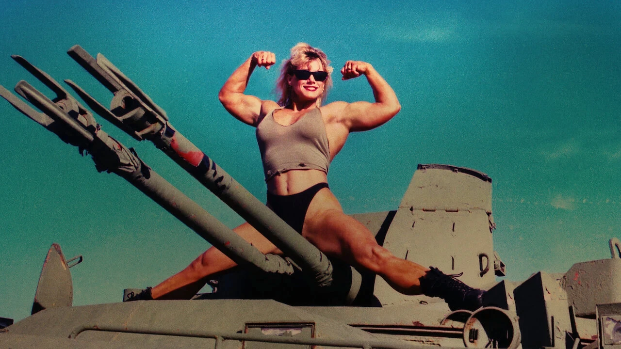 Femme sportive portant des lunettes de soleil, assise en grand écart sur un véhicule militaire, fléchit les bras pour montrer ses muscles sous un ciel bleu. L’image symbolise le développement de compétences et la formation continue comme piliers de l’excellence professionnelle et de l’attractivité d’entreprise.