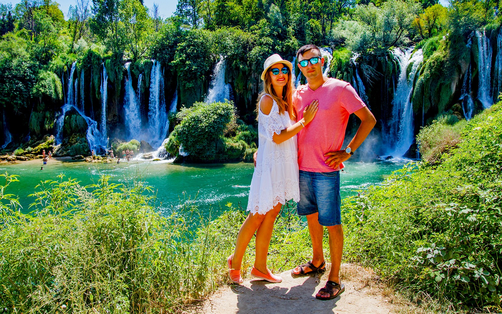一对夫妇在从斯普利特到特罗吉尔的莫斯塔尔导览游中，站在克拉维察瀑布前合影。