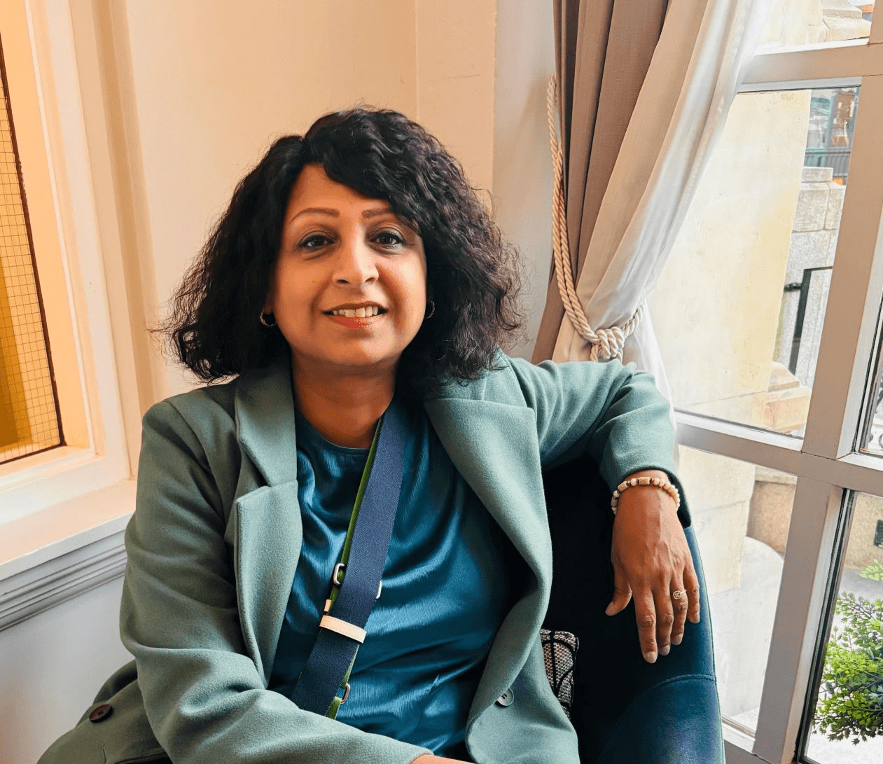 Monochrome fashion editorial of a model in an oversized white trench coat walking in profile on a high-key background.