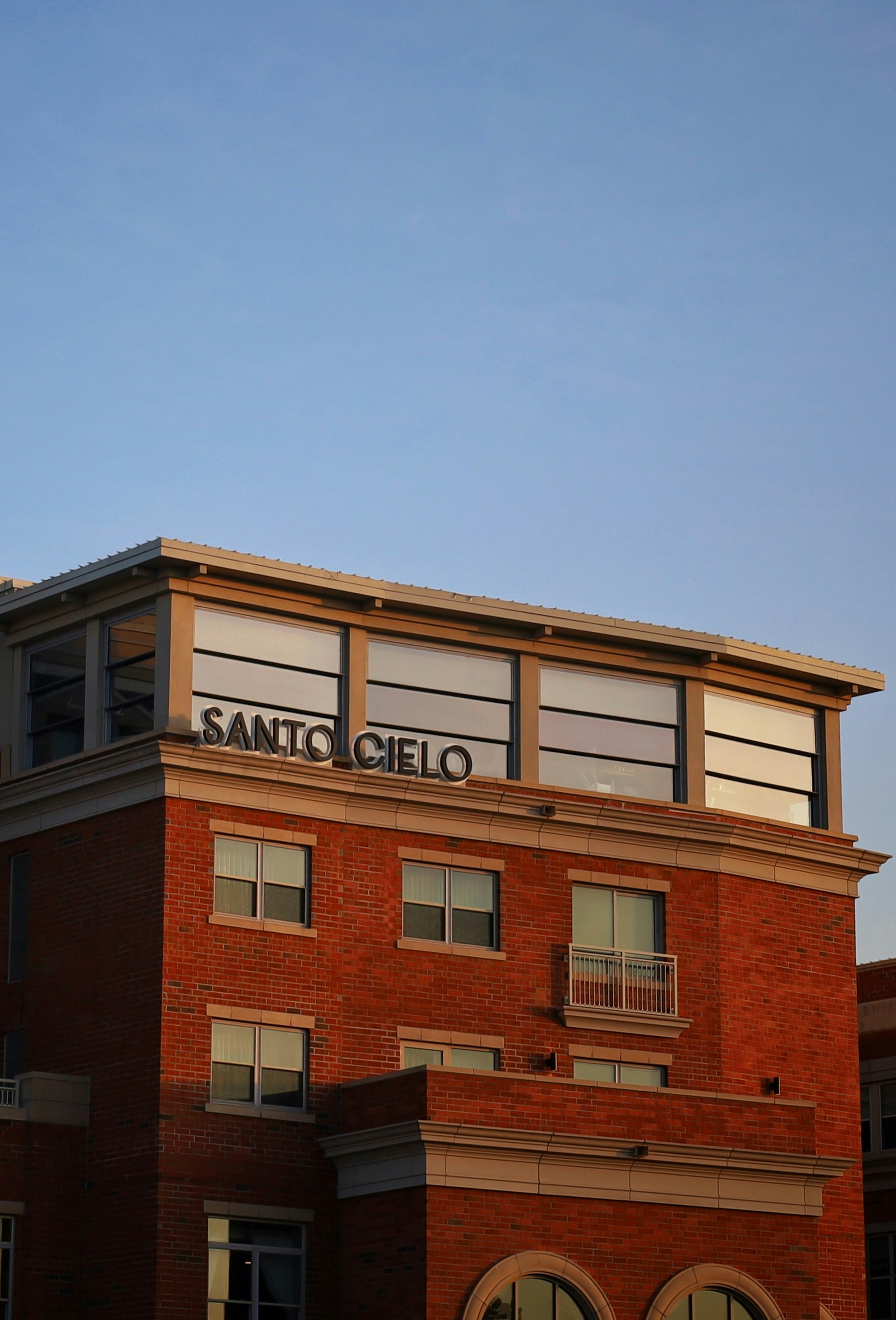 A building reads "santo cielo" against a blue sky.