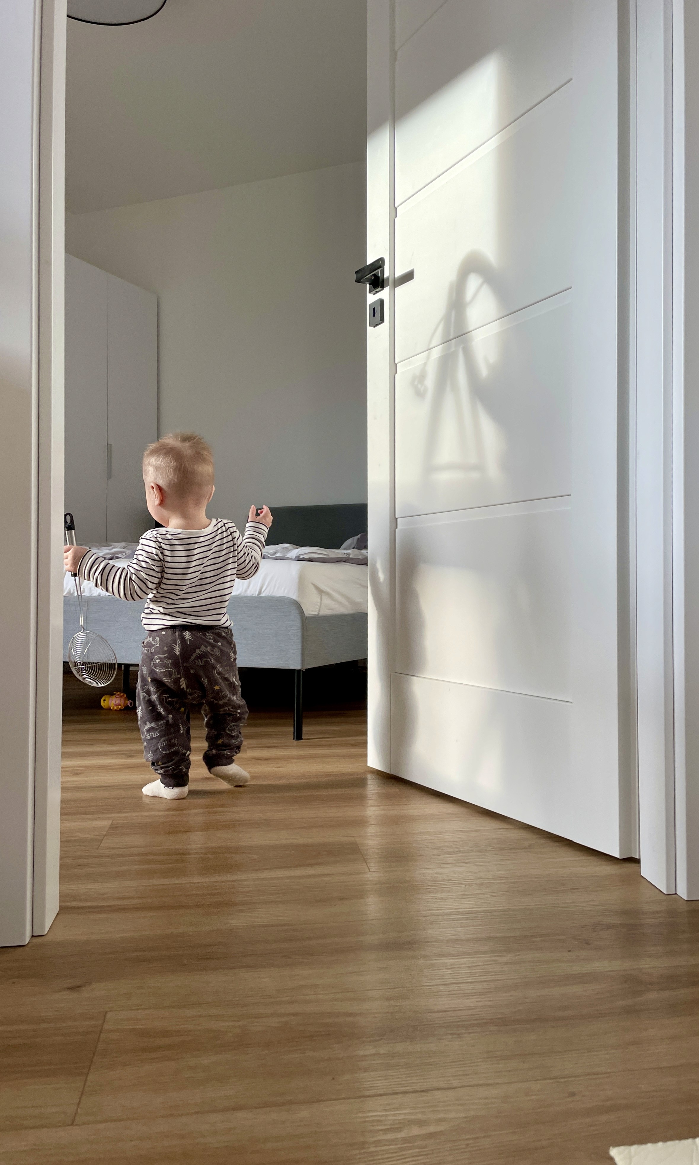 A toddler walks confidently across LUXO’s warm wood-look hybrid flooring, highlighting a safe, hypoallergenic, and easy-clean surface designed for baby-friendly Australian homes.