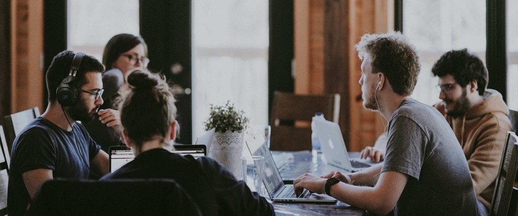 The team working together at a table with laptops, discussing business strategies or projects.