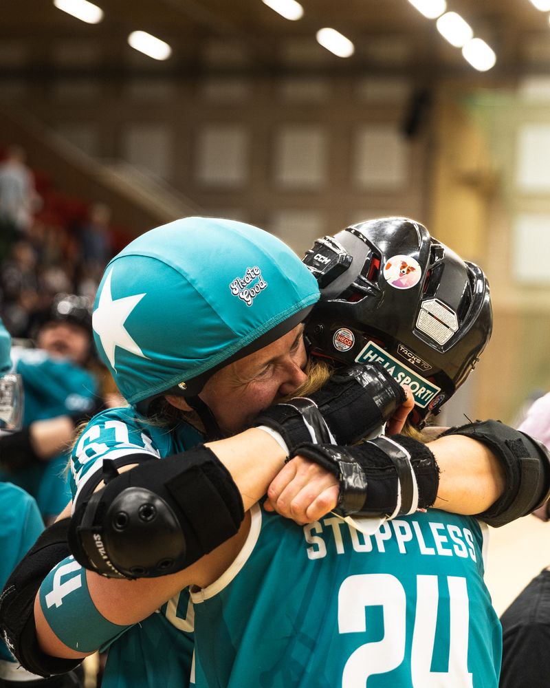 A roller derby player standing in full gear in a changing room.