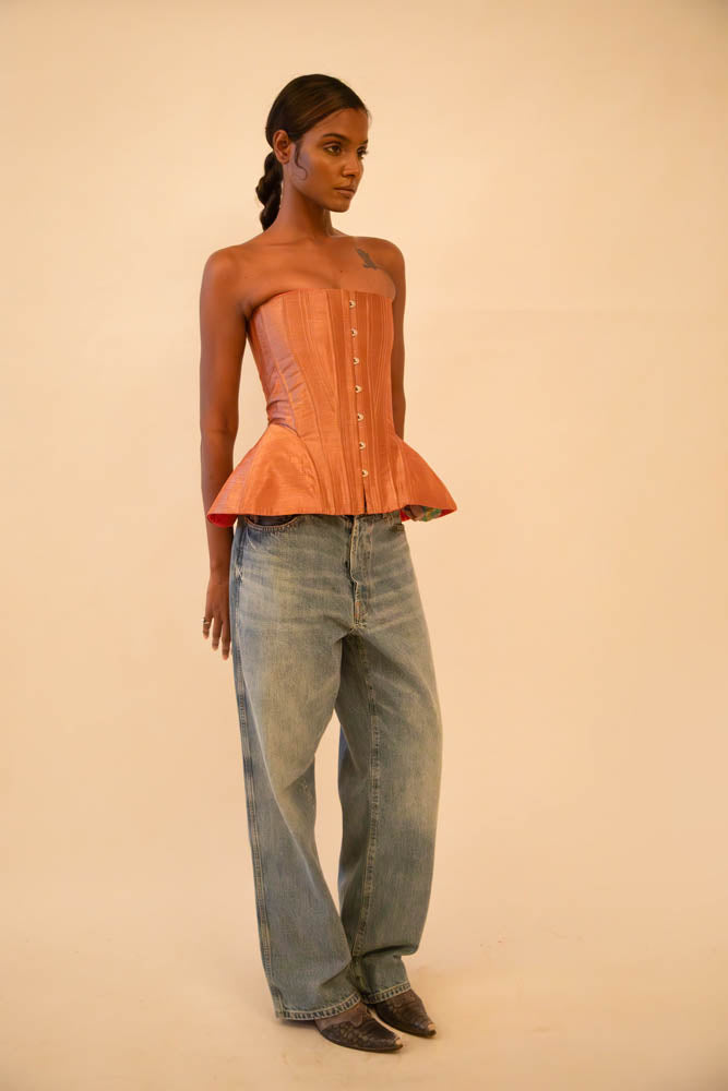 Bell corset handcrafted from a vintage rose gold silk sari, featuring front closure and adjustable lace-up back, designed for a structured fit and celebrating mindful craftsmanship.