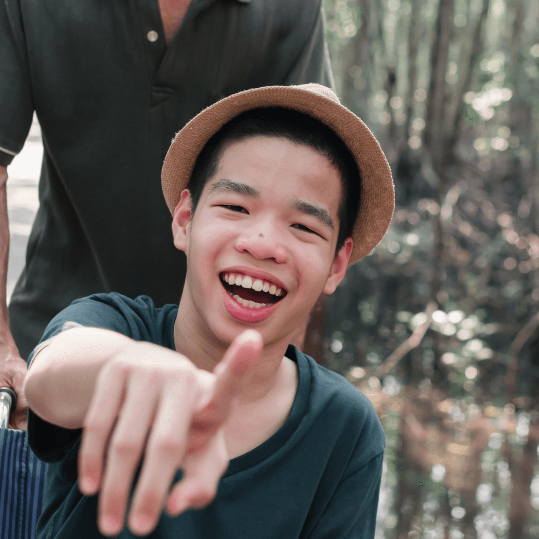 A young man smiling and pointing at the camera