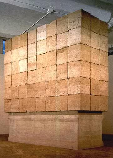 Large sculptural installation made of stacked, textured earth-toned blocks by Gay Outlaw