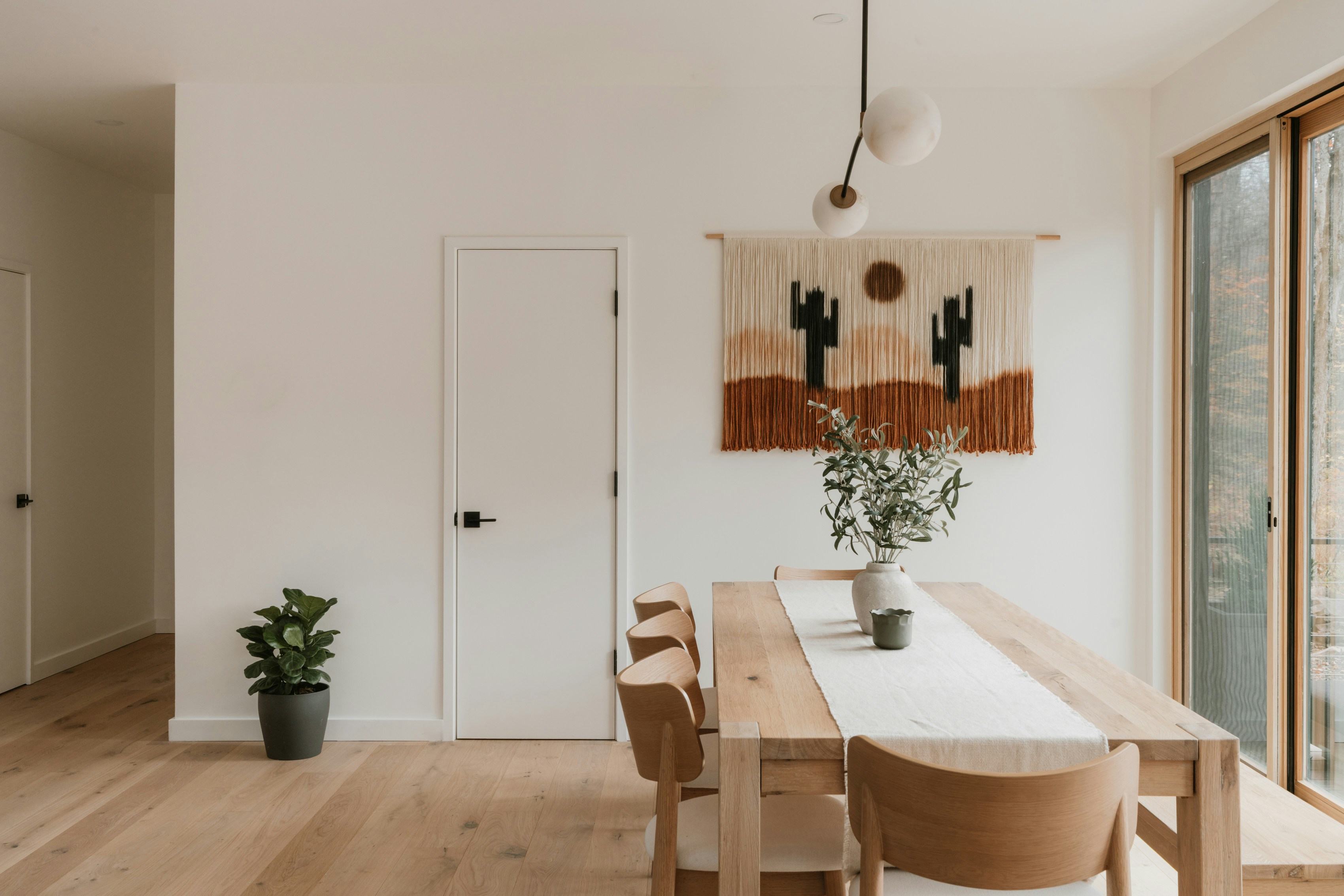 Modern dining room with desert-themed wall hanging.