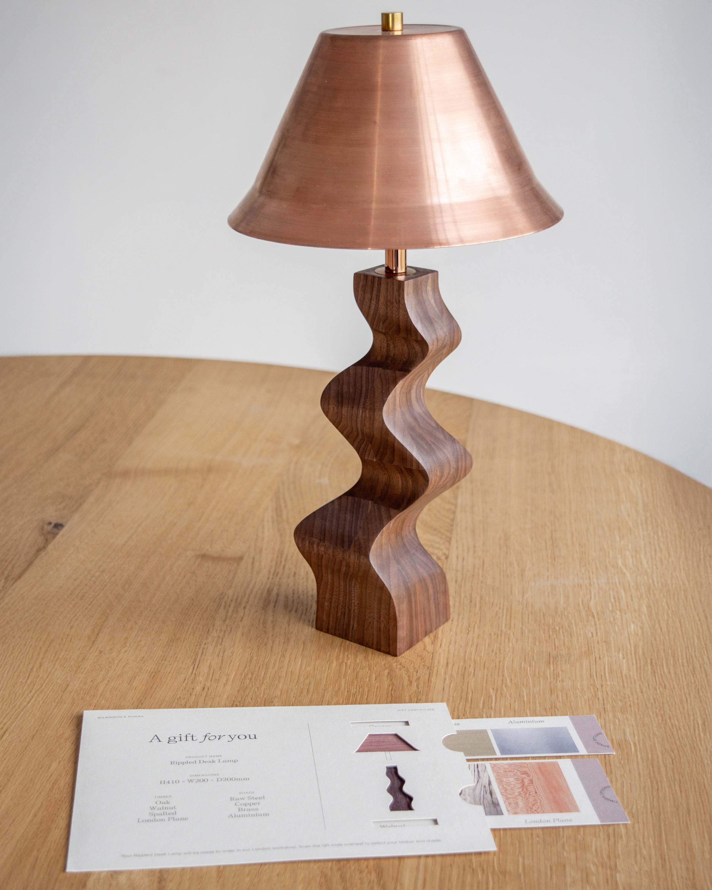 Rippled Desk Lamp in Walnut with Copper lampshade next to matching Wilkinson & Rivera gift card.