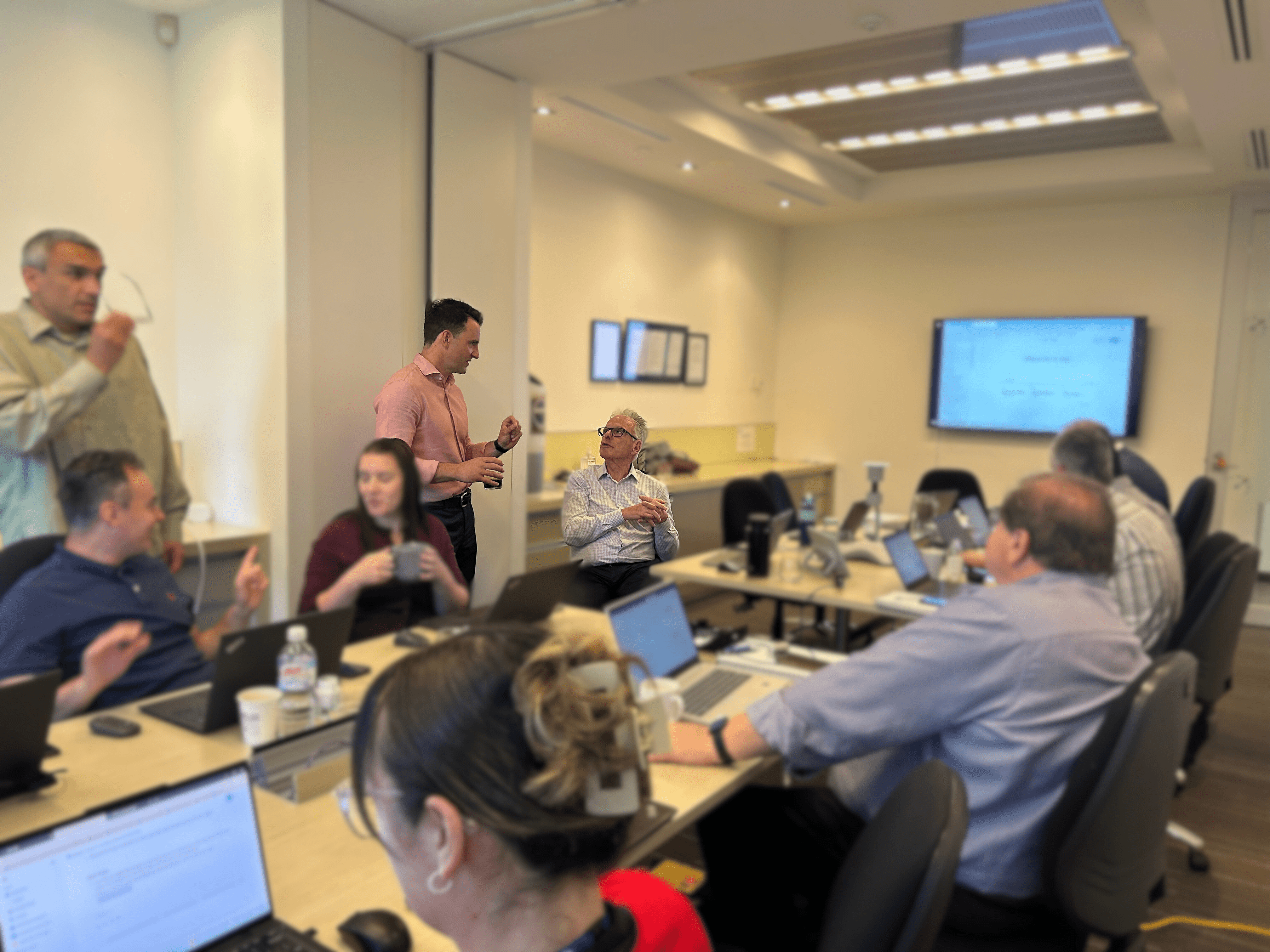 man standing in front of people sitting beside table with laptop computers