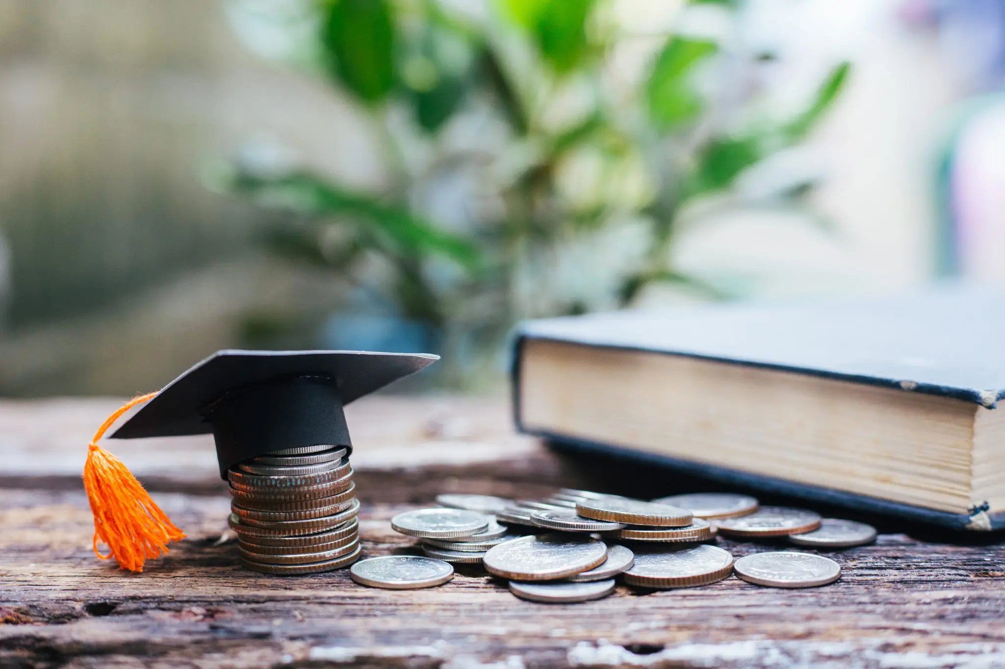 A pile of coins with a Mortarboard on top of them