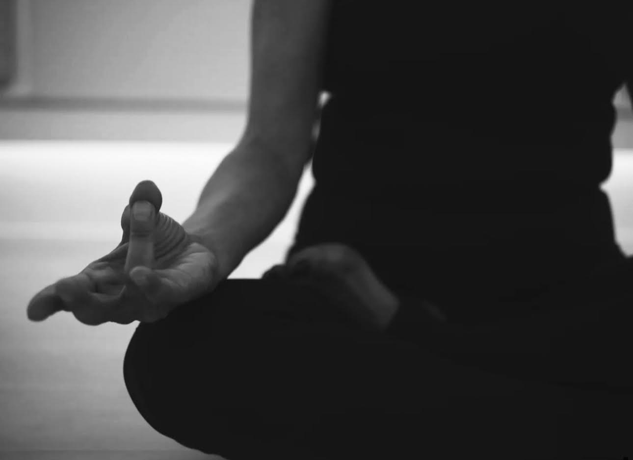 An upclose photo of a person doing a seated yoga position