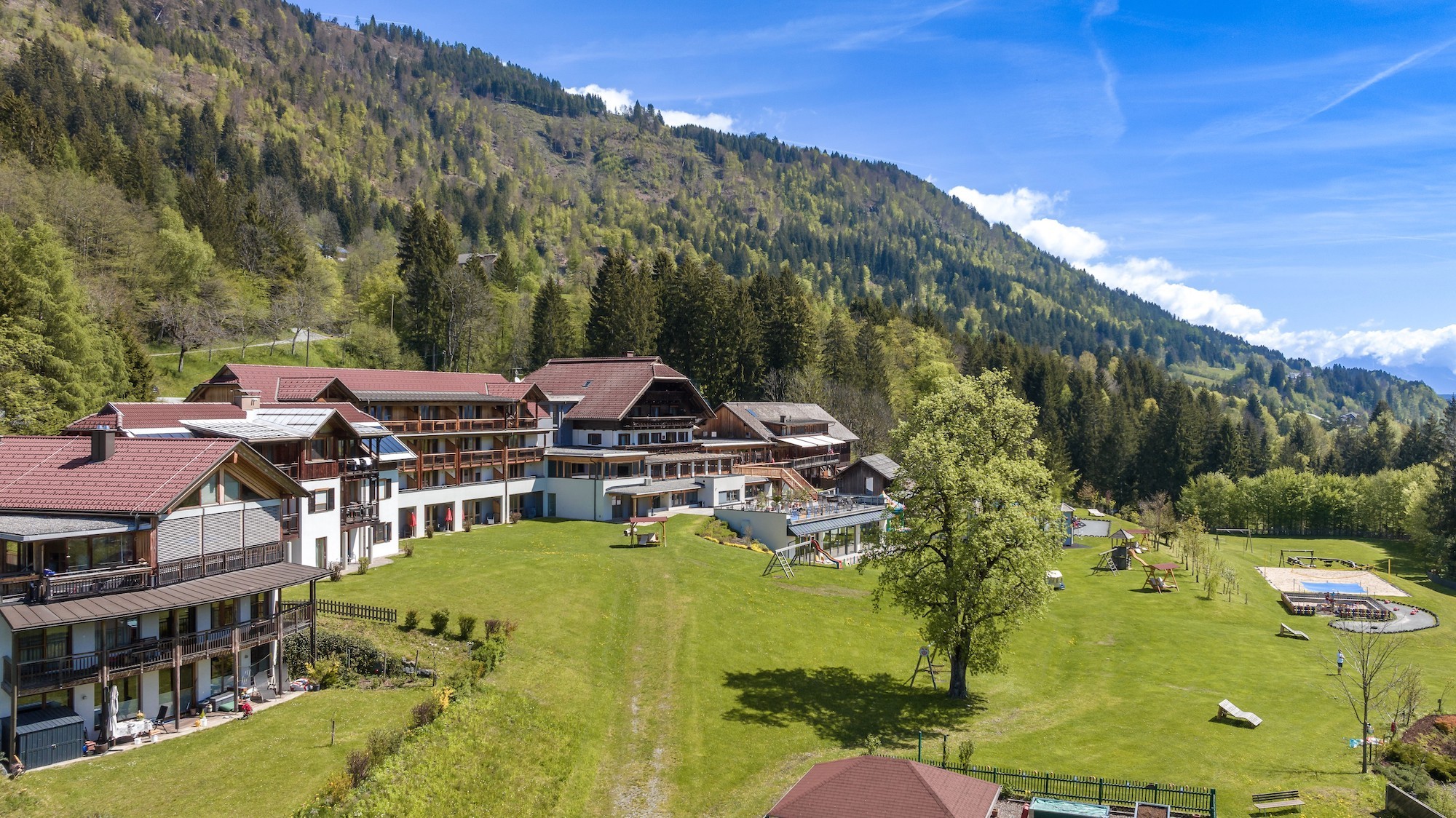 Kinderhotel Ramsi von außen umgeben von Wiesen und Wäldern.