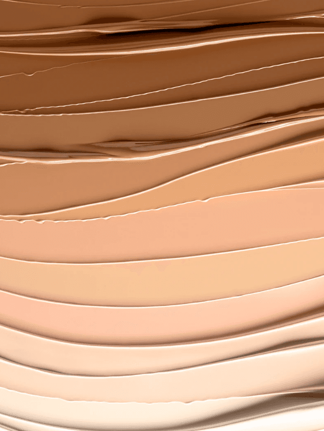 Abstract image of various shades of foundation or cream blended in smooth, wavy lines.