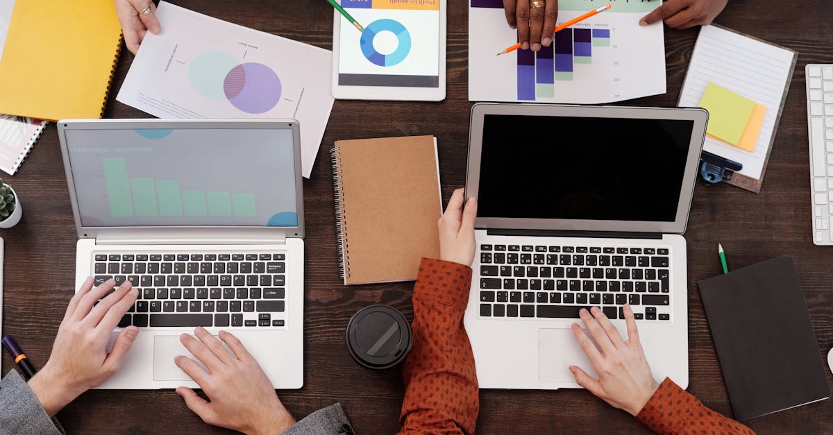 Overhead view of a team discussing digital marketing strategies with laptops and charts.