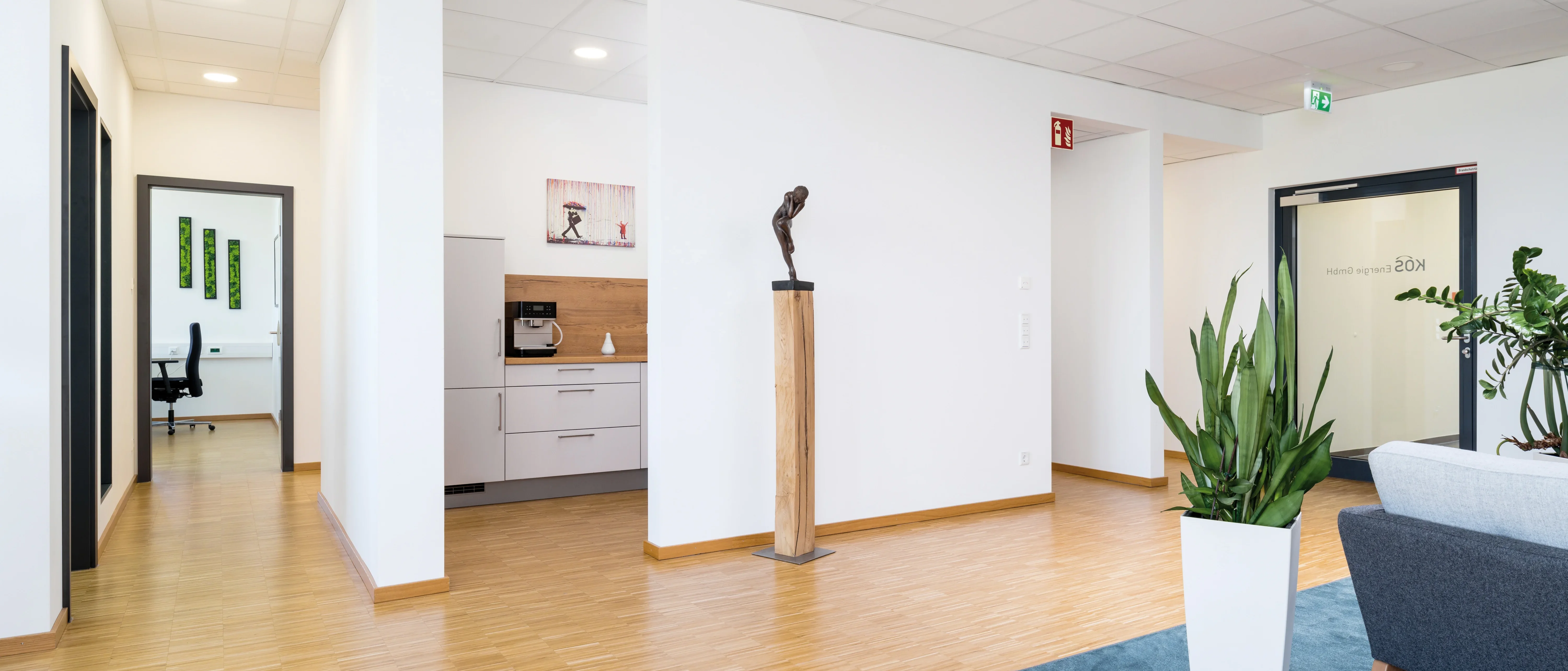Modernes Foyer mit hellem Holzboden und weißen Wänden.