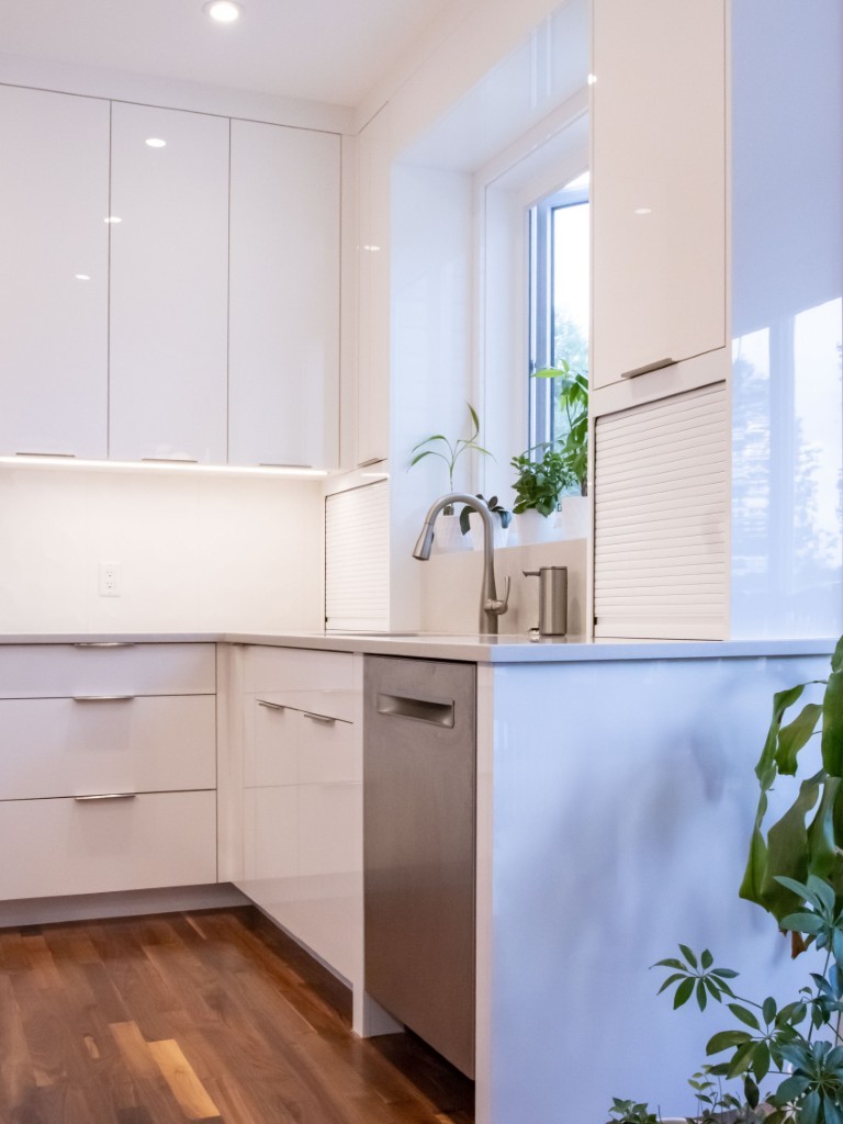 Image of Modern kitchen interior with white cabinetry, stainless steel appliances, and layout design by KHD Homes.