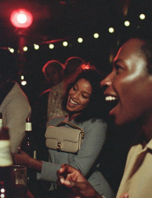 Two friends laughing under string lights