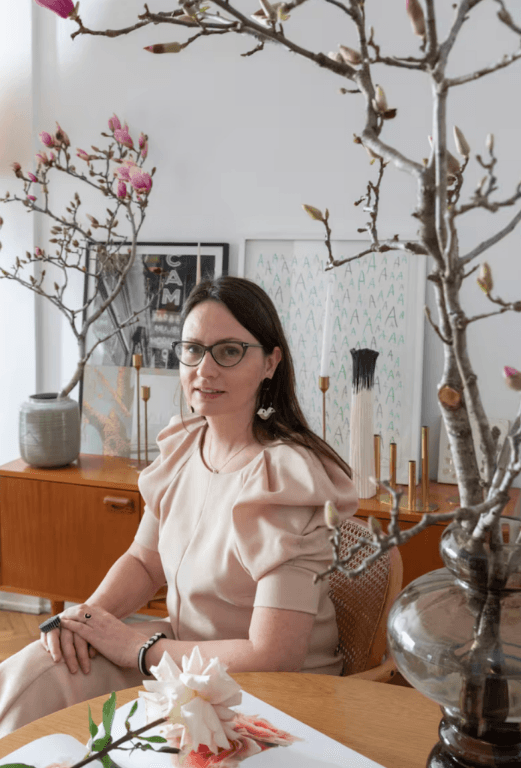 Irina Khatsernova retratada en su estudio con ramas y flores — diseñadora floral argentina y artista botánica.