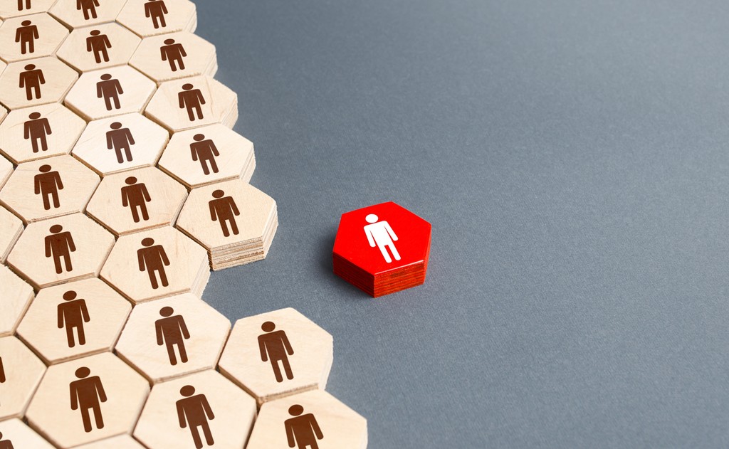 Stacks of hexagonal wooden carvings, with a single red painted hexagon singled out.