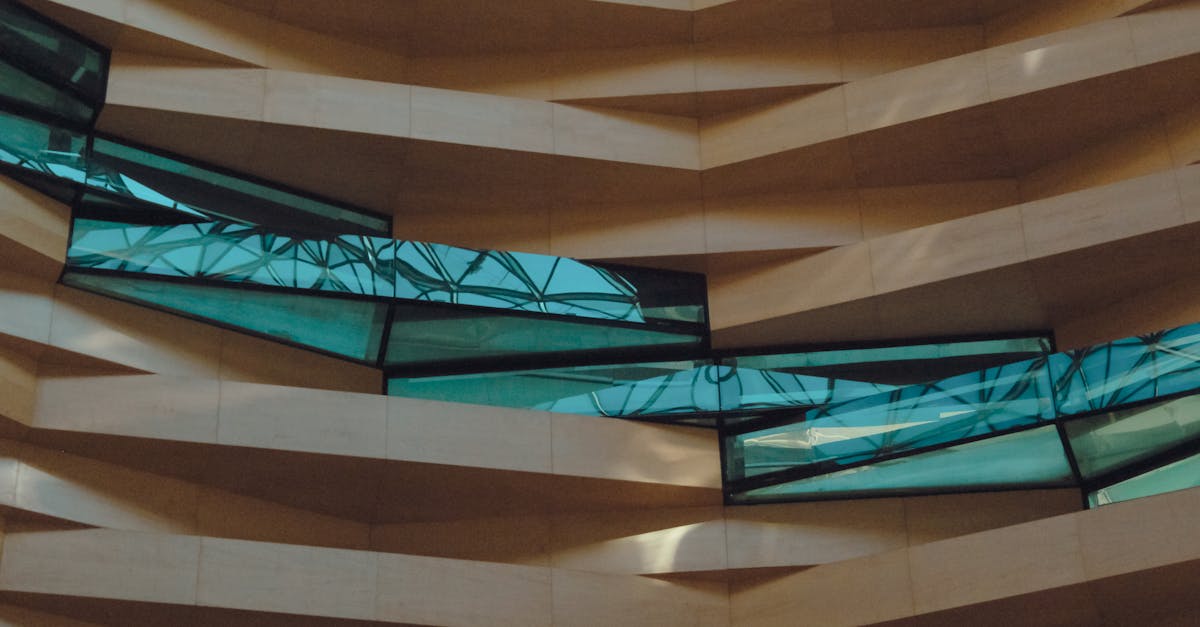 Contemporary architectural facade with angular geometric patterns and tinted glass windows.