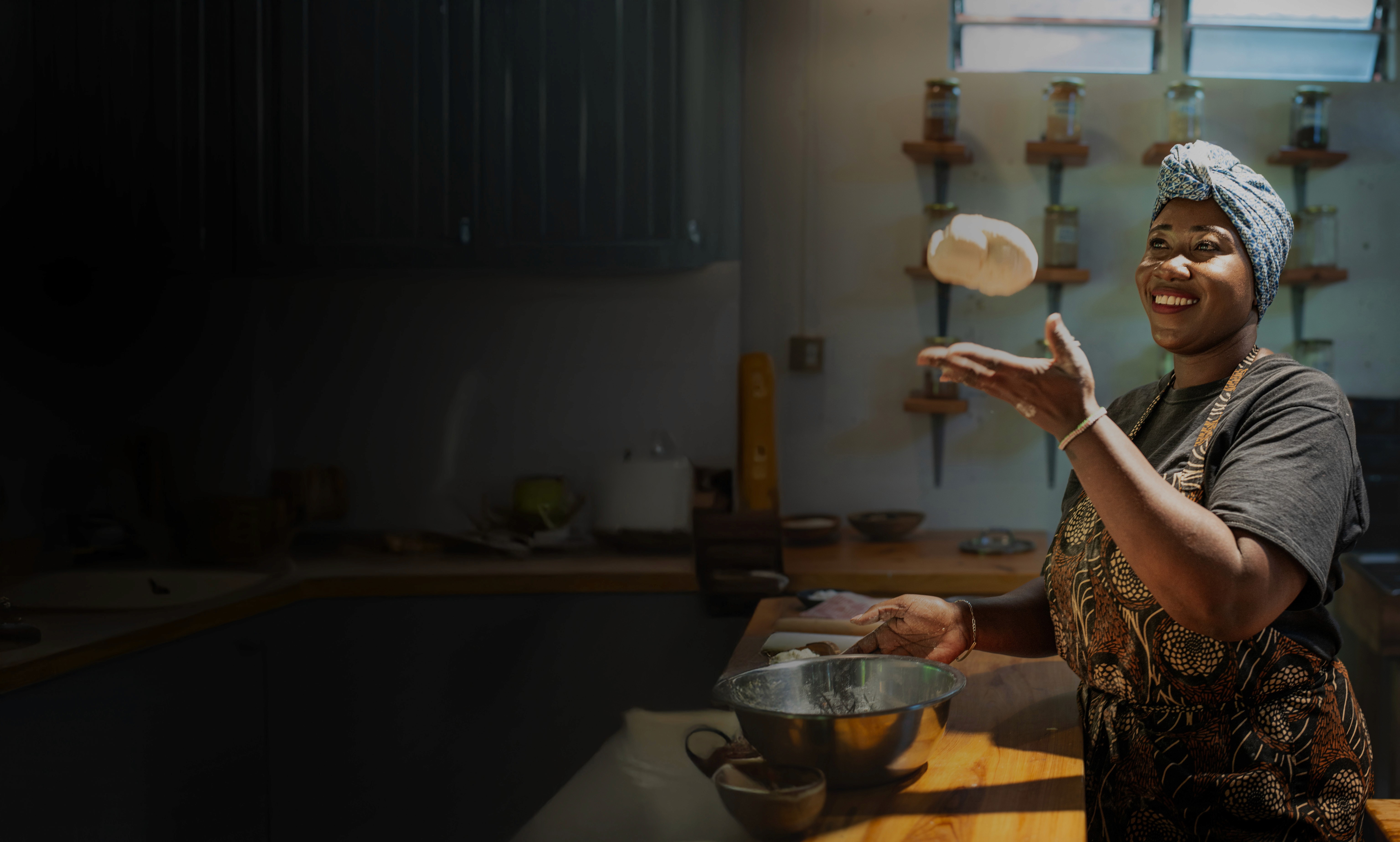 Woman preparing mandazi dough in a Nairobi kitchen using Essential's fermented protein flour