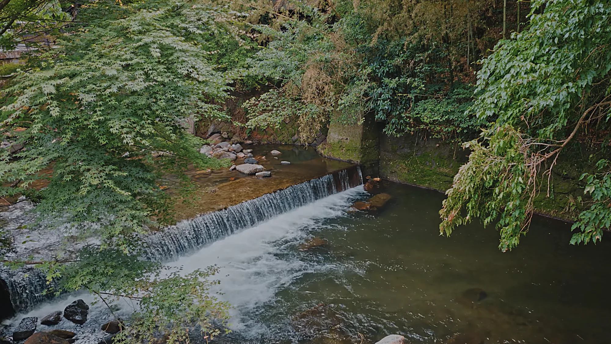 A river weir at Kurokawa Onsen under summer green
