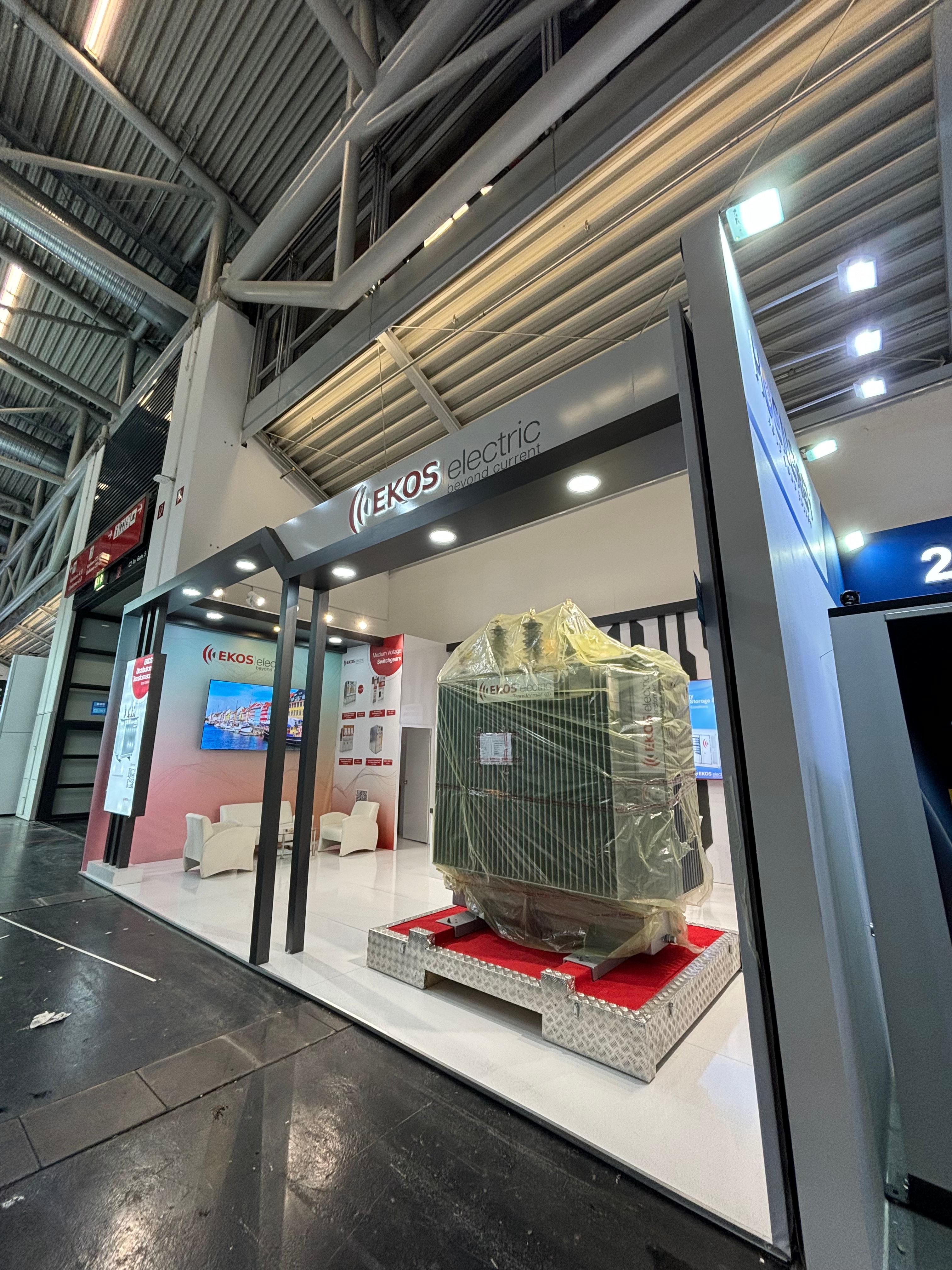 Large physical transformer displayed on a raised base at the Ekos Electric stand, creating immediate impact and credibility.