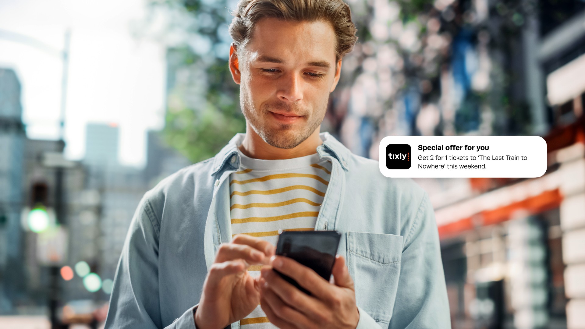 Man on street getting a message with an offer send through Tixly's CRM system