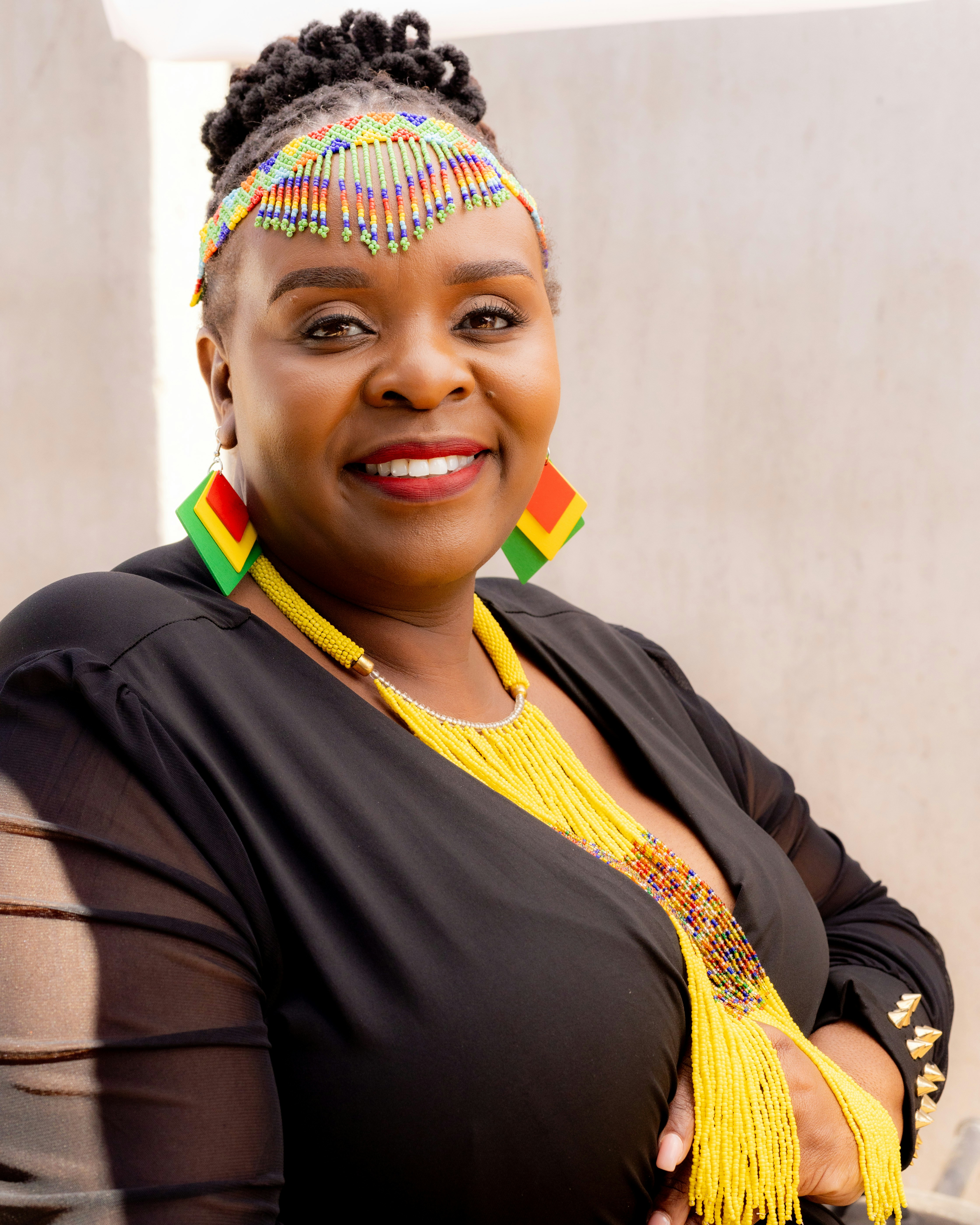A smiling woman wearing colorful beaded jewelry